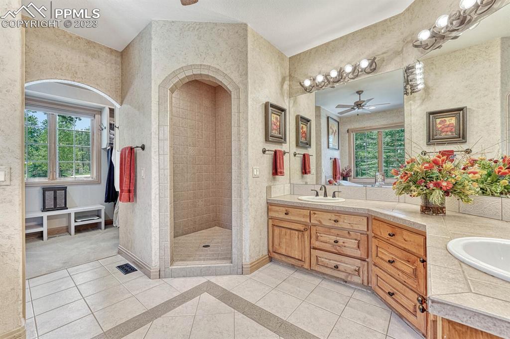 17890 Queensmere Drive Monument, CO 80132 - Photo 22 of 50 a spacious bathroom with a granite countertop sink a mirror and shower