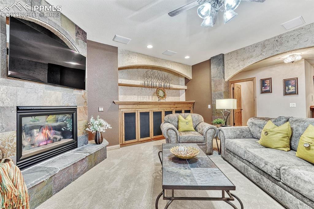 17890 Queensmere Drive Monument, CO 80132 - Photo 25 of 50 a living room with furniture and a fireplace