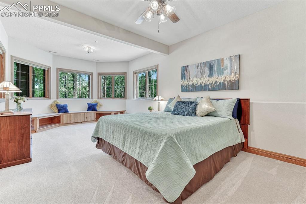 17890 Queensmere Drive Monument, CO 80132 - Photo 36 of 50 a bedroom with a large bed and a large window