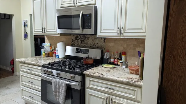 a kitchen with granite countertop a stove and a sink