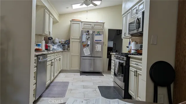 a kitchen with stainless steel appliances a refrigerator sink and cabinets