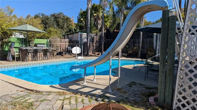 a view of a house with backyard water fountain and sitting area