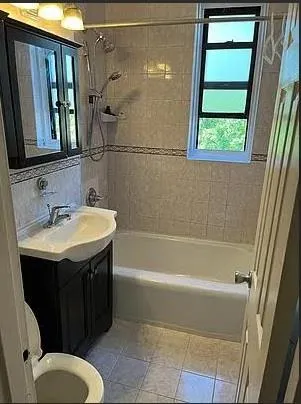 a bathroom with a sink and mirror with bathtub