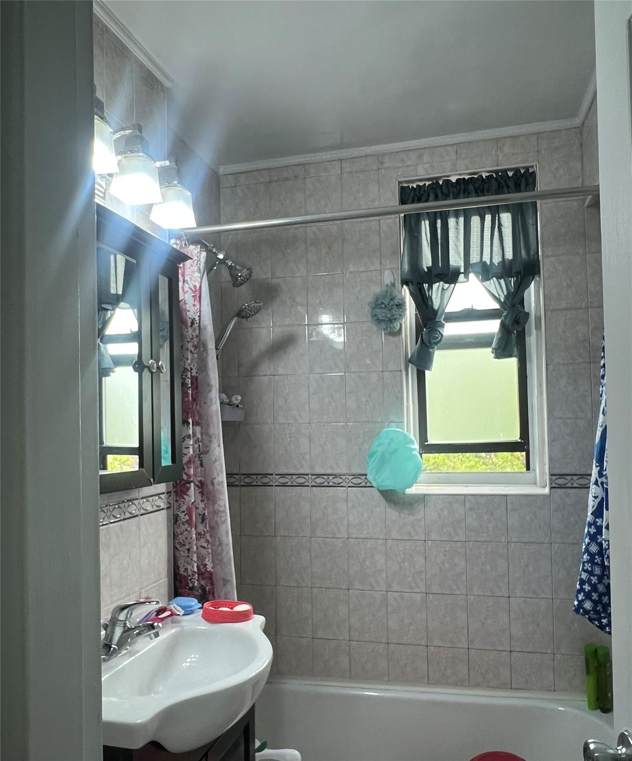84-23 Manton Street, Unit 4A Queens, NY 11435 - Photo 18 of 18 a bathroom with a sink and mirror with bathtub