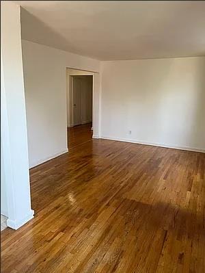 84-23 Manton Street, Unit 4A Queens, NY 11435 - Photo 7 of 18 a view of an empty room with wooden floor and a window