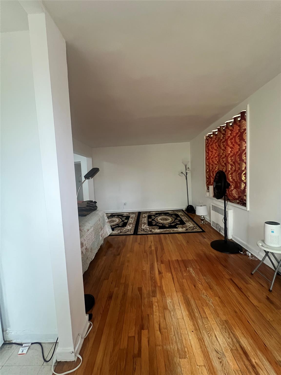 84-23 Manton Street, Unit 4A Queens, NY 11435 - Photo 10 of 18 view of a room with wooden floor and wardrobe