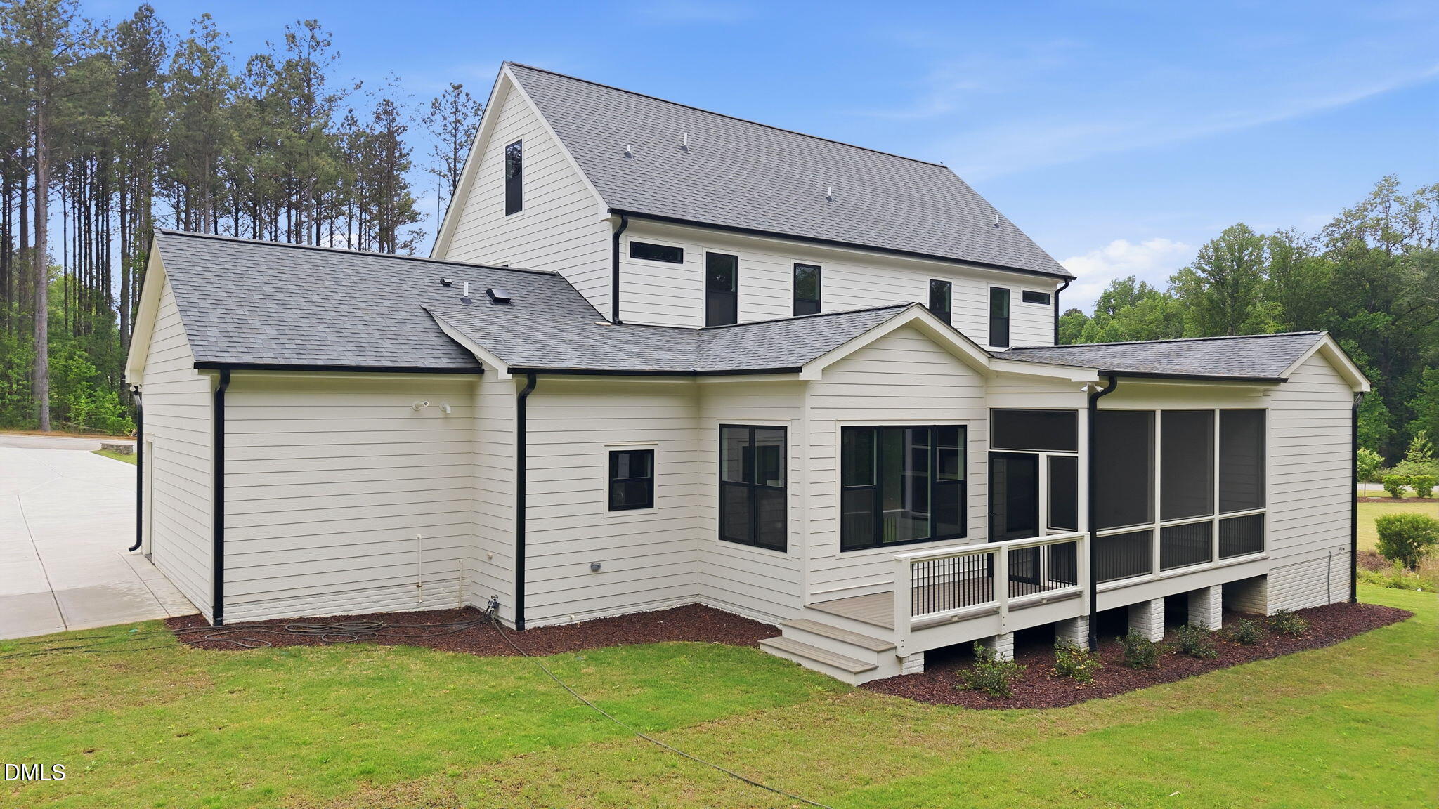 1304 Sanctuary Pond Drive Raleigh, NC 27606 - Photo 46 of 52 a view of a white house with large windows and a yard with wooden fence