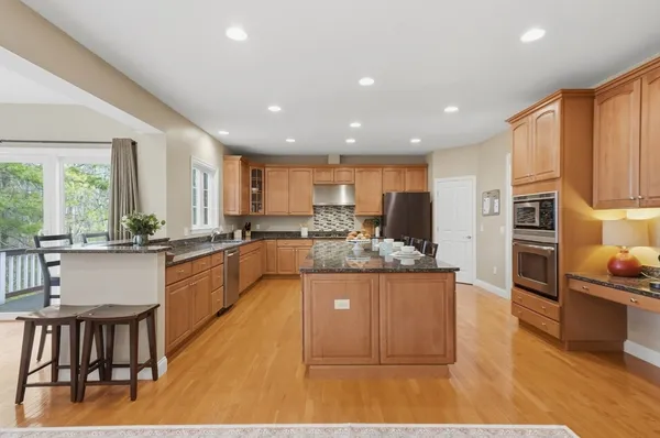 a large white kitchen with a large window and stainless steel appliances