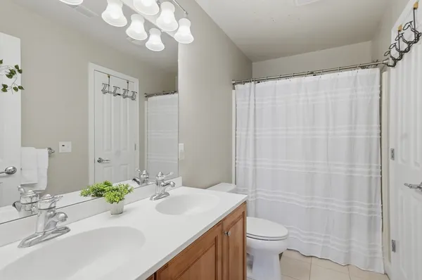 a bathroom with a sink a toilet and shower curtain