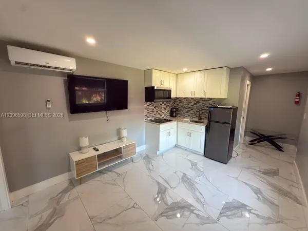 a kitchen with stainless steel appliances kitchen island granite countertop a sink and a stove top oven with wooden floor