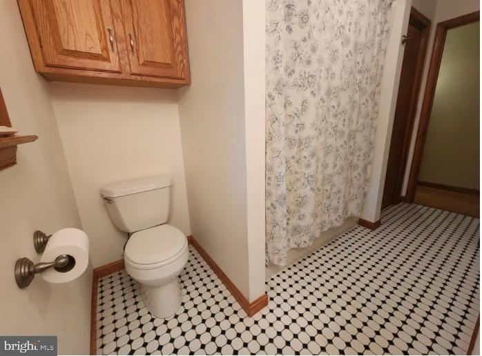 3869 Midstate Road Felton, DE 19943 - Photo 26 of 37 a bathroom with a toilet and a shower curtain