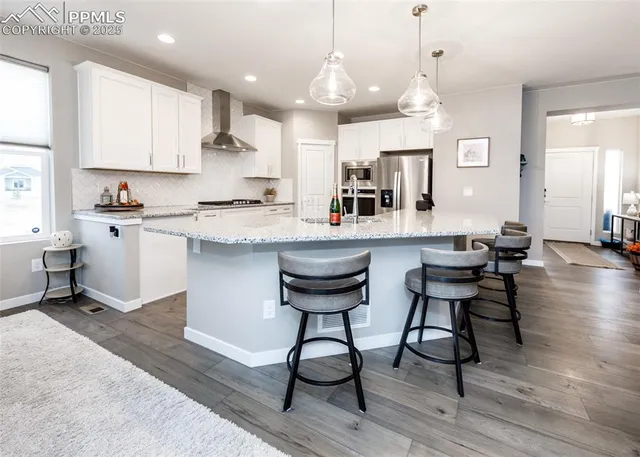 a kitchen with stainless steel appliances granite countertop a kitchen island a stove and a sink