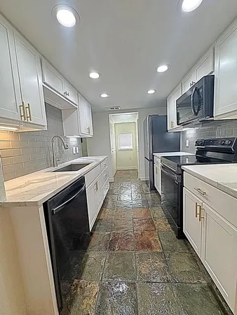 a kitchen with stainless steel appliances granite countertop a sink stove and microwave