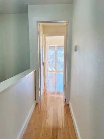 a view of a hallway with wooden floor