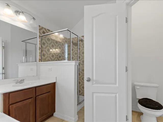 a spacious bedroom with a bed and a chandelier