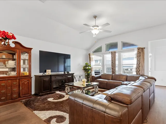 a living room with furniture a flat screen tv and a large window