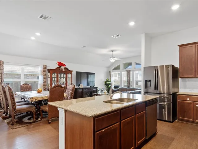 a kitchen with granite countertop a sink stove and refrigerator