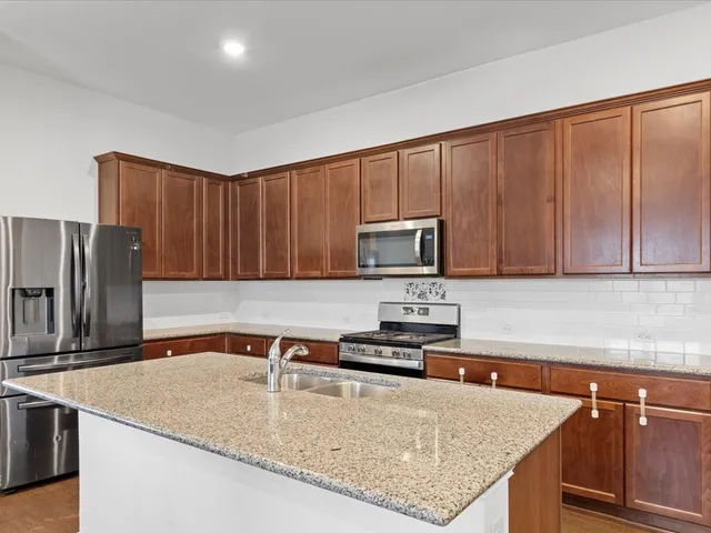 a kitchen with sink refrigerator and cabinets