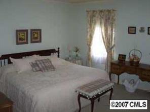 3200 Sharon Road, Unit 1 Charlotte, NC 28211 - Photo 6 of 8 a bed sitting in a bedroom next to a window