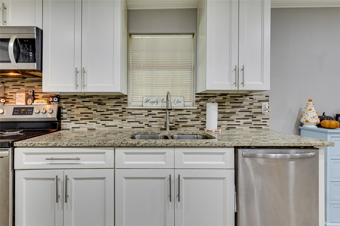 110 Avondale Road Anderson, SC 29624 - Photo 20 of 26 A well-appointed kitchen features a double-basin sink, sleek cabinetry, and a modern mosaic tile backsplash.