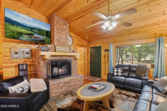 a living room with furniture a fireplace and a floor to ceiling window