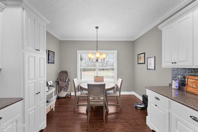 a dining room with furniture a chandelier and wooden floor