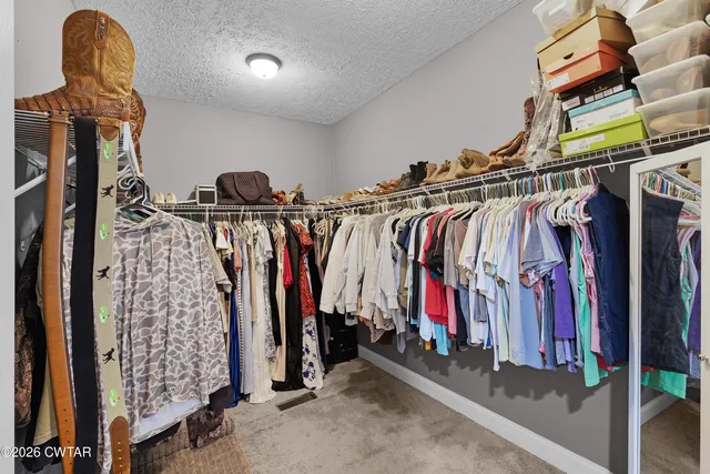 a view of walk in closet with clothes