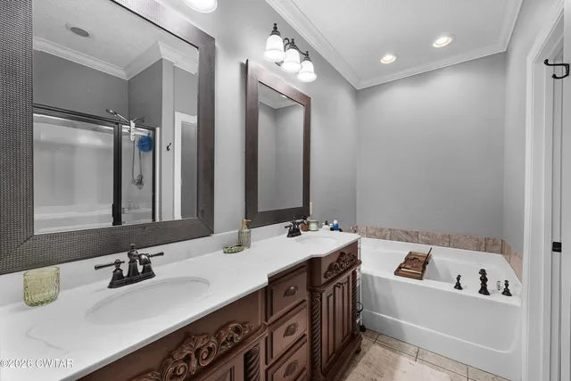 a bathroom with a tub a sink double vanity and a mirror