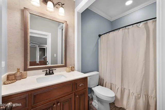 a bathroom with a sink vanity mirror and toilet