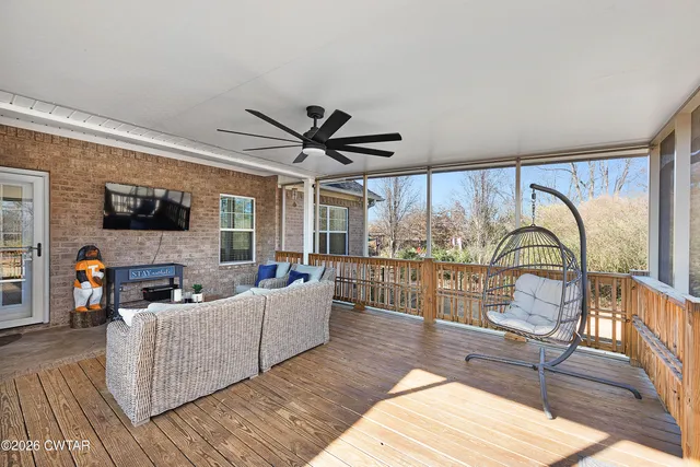 a living room with furniture a flat screen tv and a floor to ceiling window
