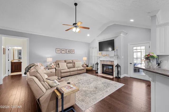 a living room with furniture a fireplace and a flat screen tv