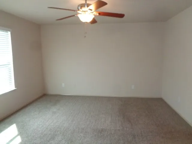 an empty room with a chandelier fan