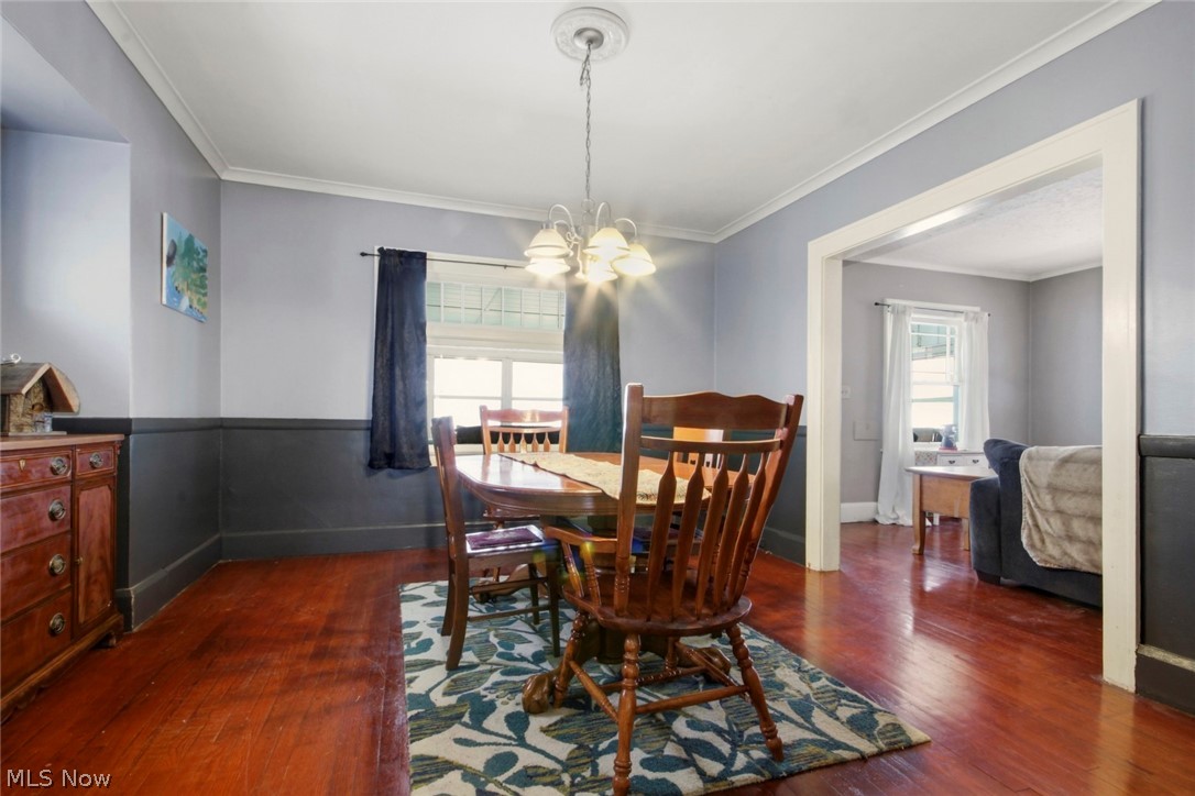 32 Como Street Struthers, OH 44471 - Photo 12 of 22 Dining area featuring dark wood-style flooring, hanging lights, and ornamental molding