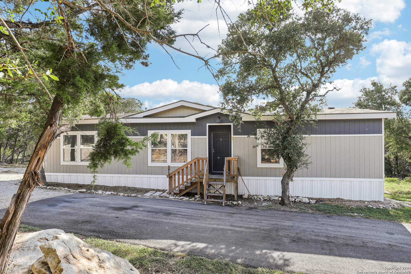 a front view of a house with a tree