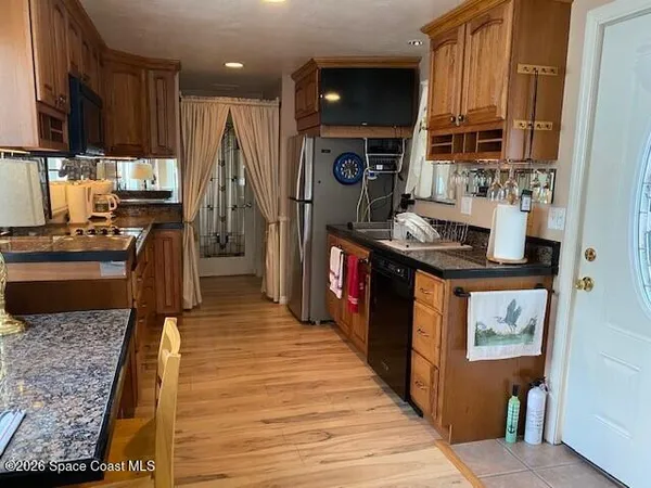a kitchen with stainless steel appliances granite countertop a refrigerator a stove and a sink