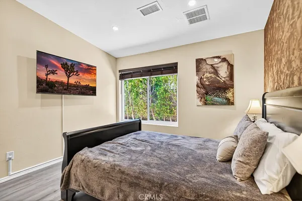 a bed sitting in a bedroom next to a window