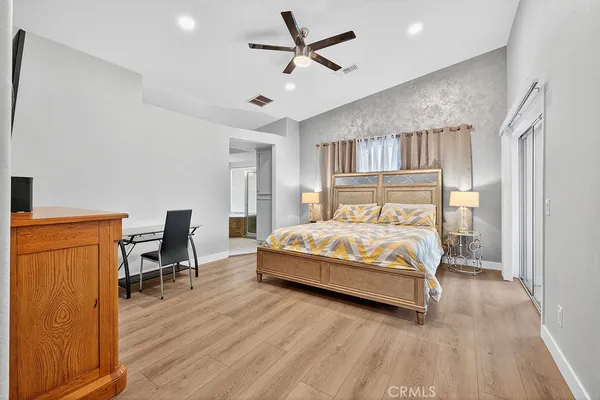 a bed sitting in a spacious bedroom next to a window