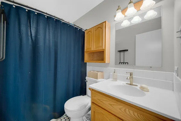 a bathroom with a sink vanity mirror and toilet
