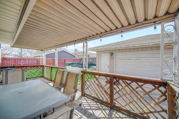 a view of a patio with table and chairs with wooden floor and fence