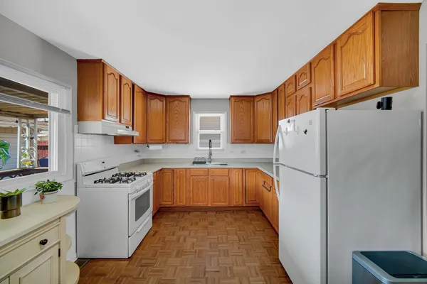 a kitchen with stainless steel appliances granite countertop a refrigerator sink stove and cabinets
