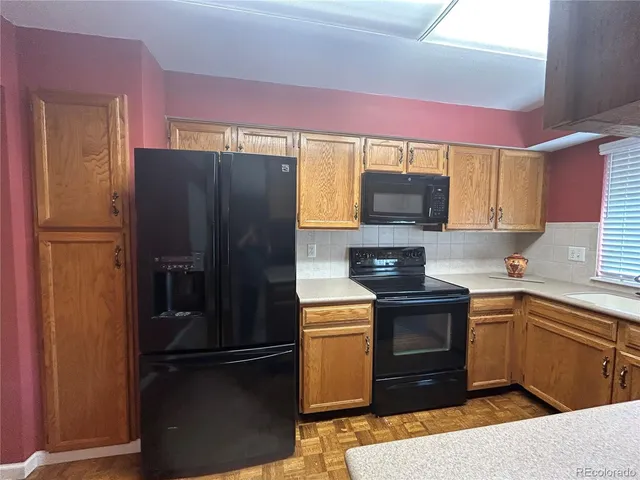 a kitchen with a refrigerator and a stove top oven