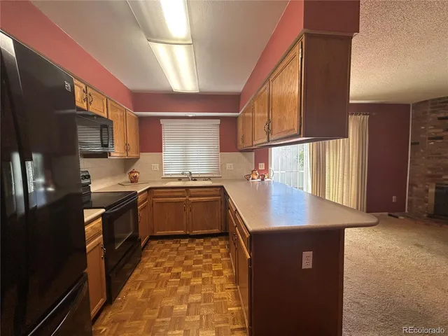 a kitchen with stainless steel appliances granite countertop a sink a stove top oven a counter space and cabinets