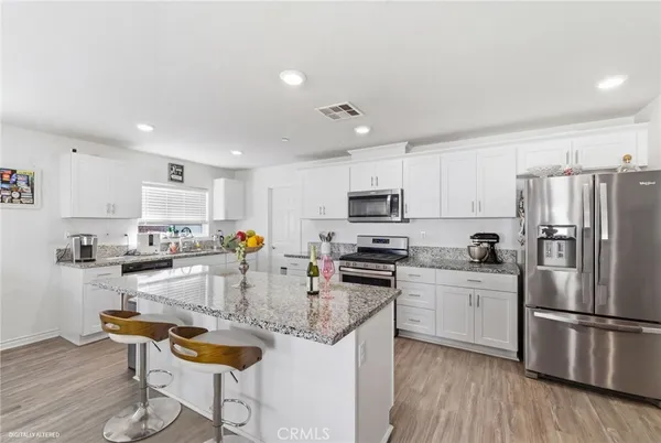 a kitchen with stainless steel appliances granite countertop a refrigerator stove microwave and sink