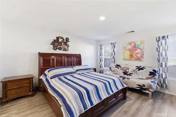 a bedroom with bed and wooden floor