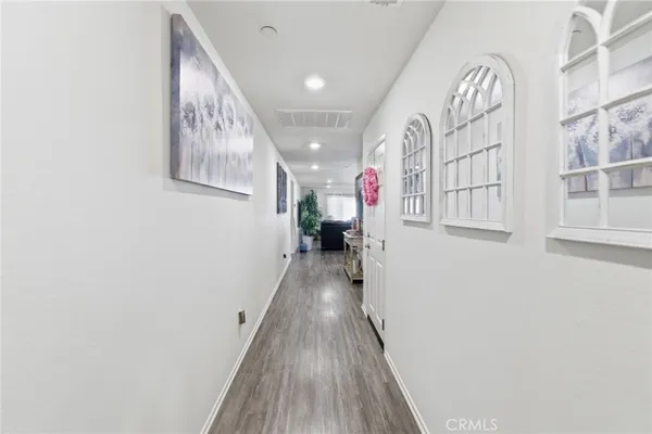 a view of a hallway with wooden floor and entryway