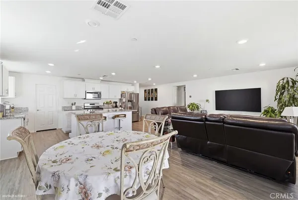 a kitchen with stainless steel appliances kitchen island granite countertop a sink and a refrigerator