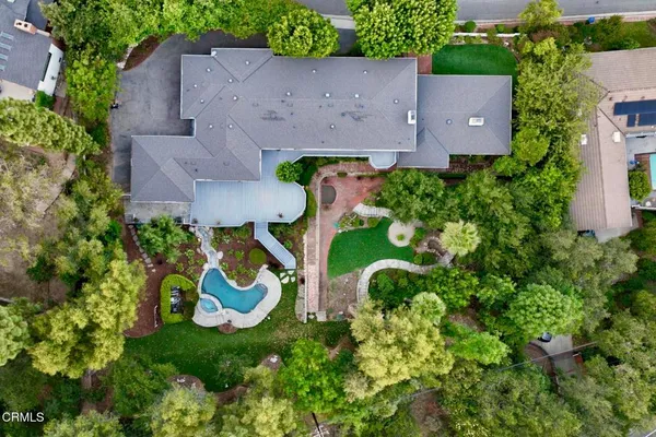 an aerial view of a house with swimming pool and a yard