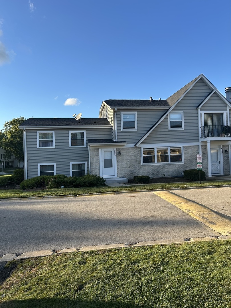 2186 North Oakbrook Circle, Unit 2186 Palatine, IL 60074 - Photo 1 of 11 a front view of a house with a yard and potted plants