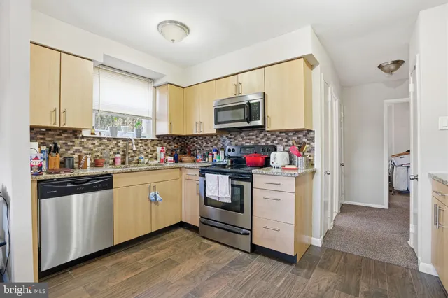 a kitchen with granite countertop white cabinets and stainless steel appliances