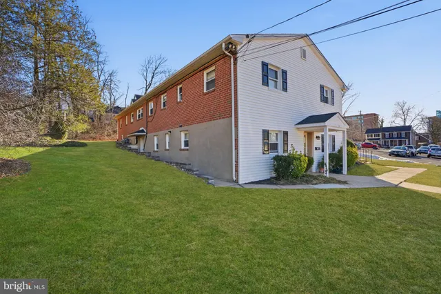 a front view of house with yard and trees in the background